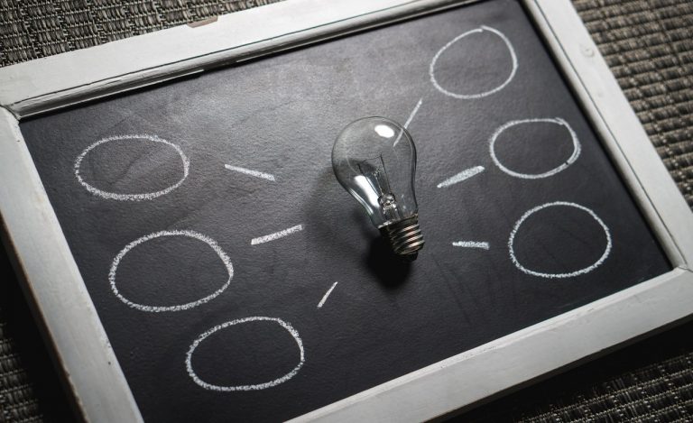 A light bulb on a black chalkboard