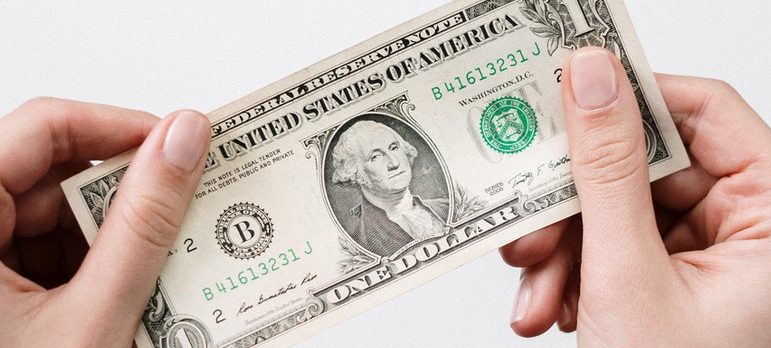 a person holding a 1 dollar bill