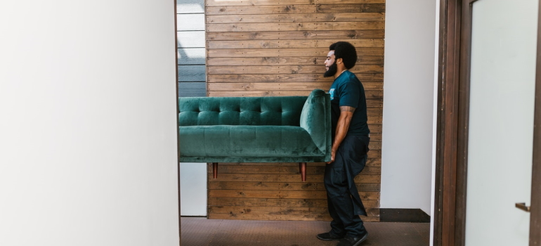 A man moving a couch