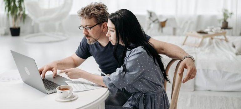 A couple using a laptop to plan how to move expensive art to their new home
