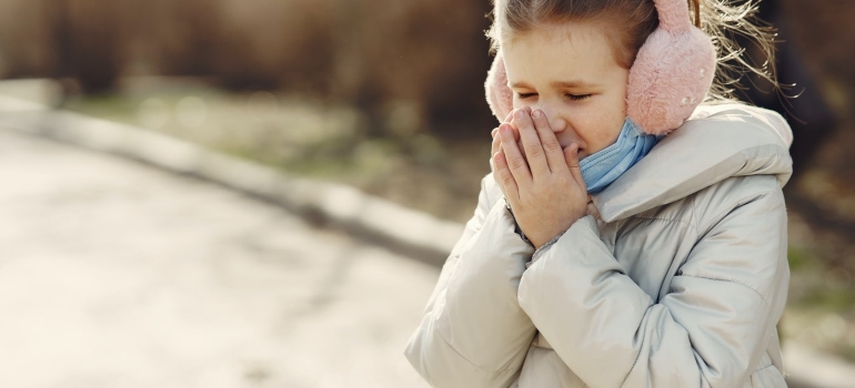 A girl sneezing in cold climate