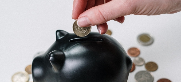 person putting money in the piggy bank