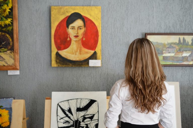 Visitors admiring artwork after you decide on moving your art gallery to Brockville