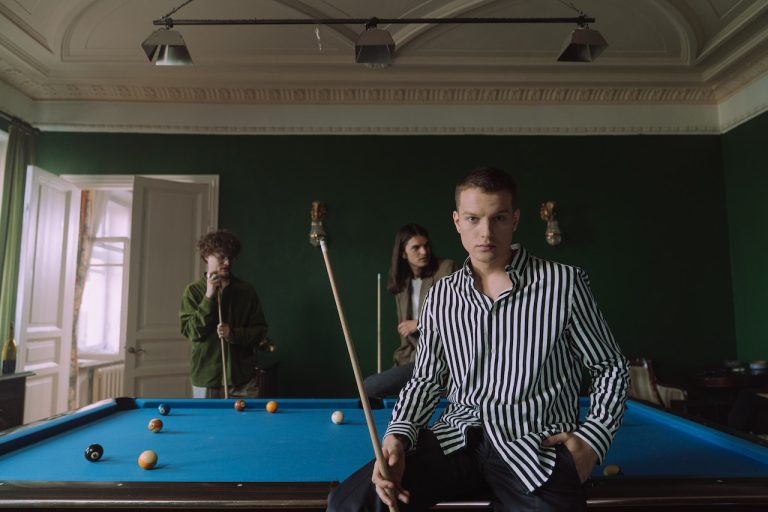 Friends playing pool after you place your pool table in optimal position