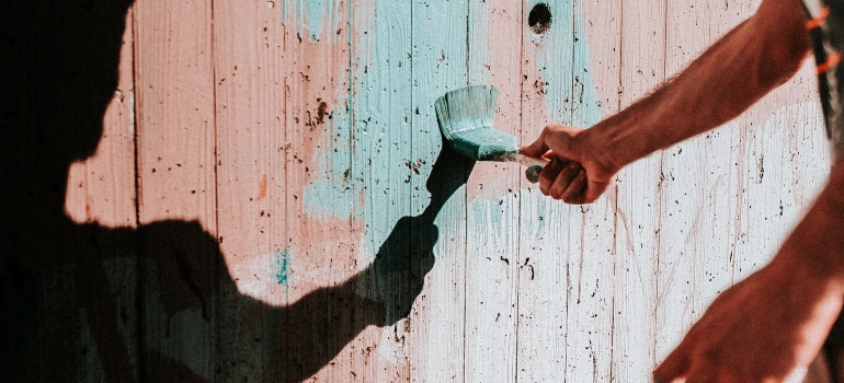 Picture of a person painting a fence 