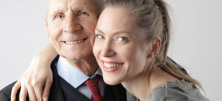 A woman hugging her elderly father
