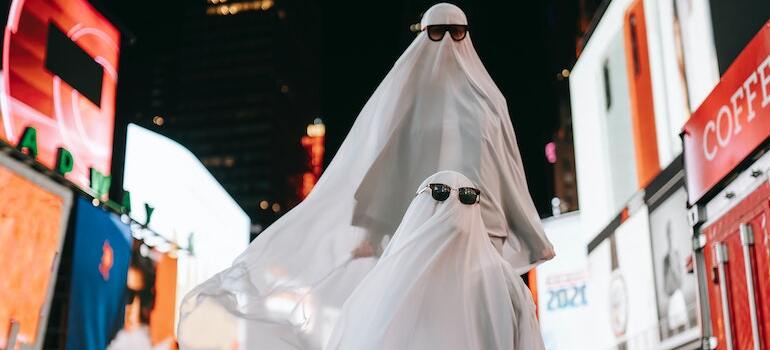 A couple dressed as ghosts wanting to spend Halloween in Ottawa at a street carnival