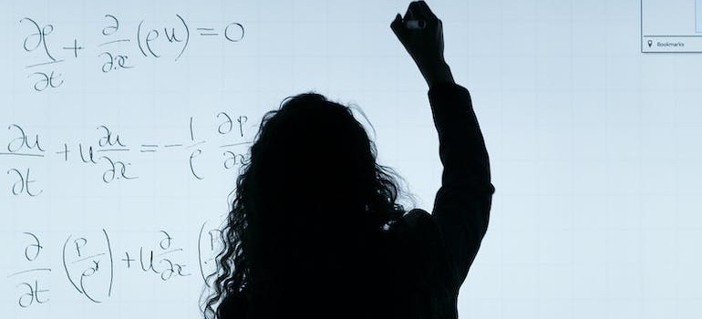 A teacher writing on a whiteboard