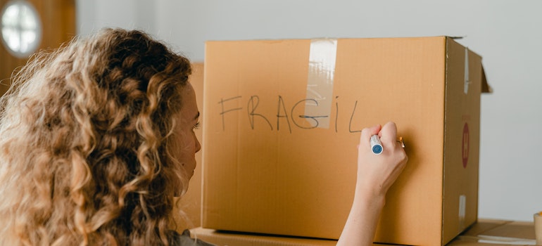 A woman labeling the moving box
