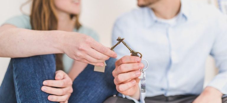 a couple sitting and holding keys