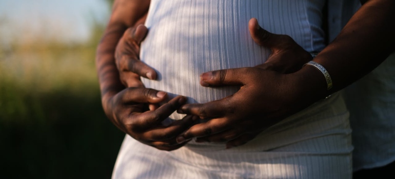 a pregnant woman and a man holding her belly