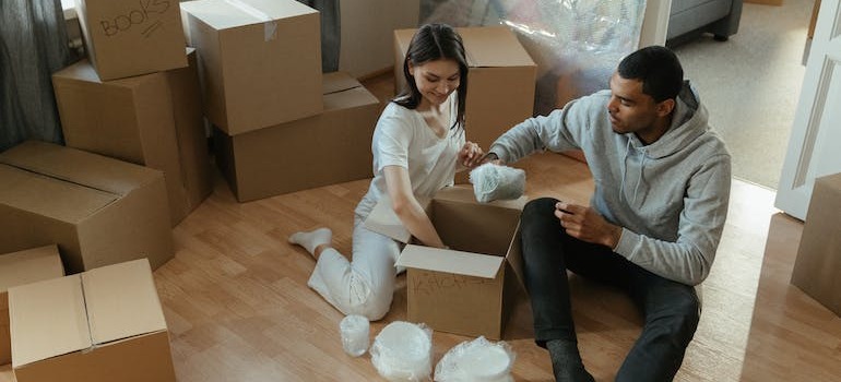 A couple unpacking items out of a moving box