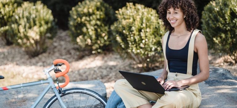 Woman working on her laptop outside in the nature