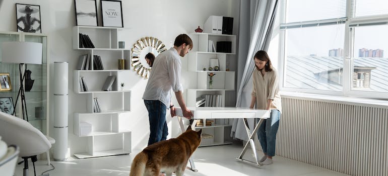 a couple moving a white desk