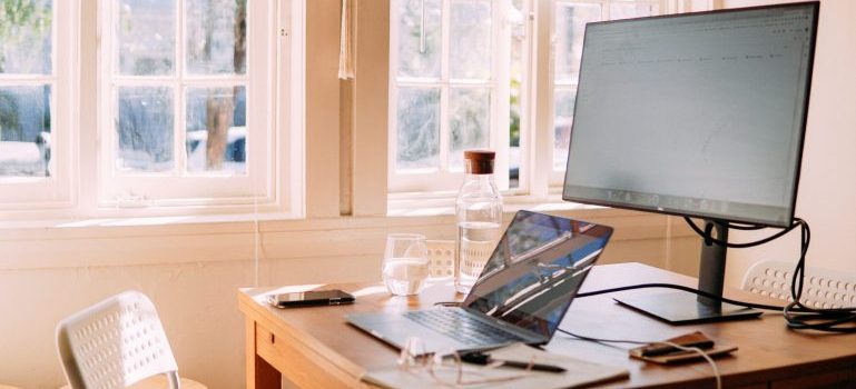 A computer and a laptop on a table in one of the small places near Ottawa perfect for remote workers