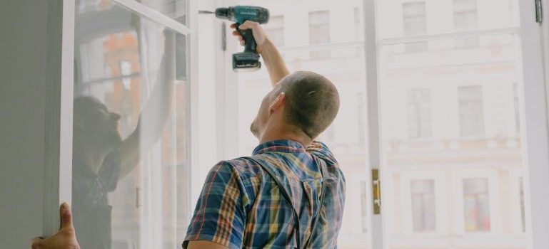 Man using a tool to fix a window