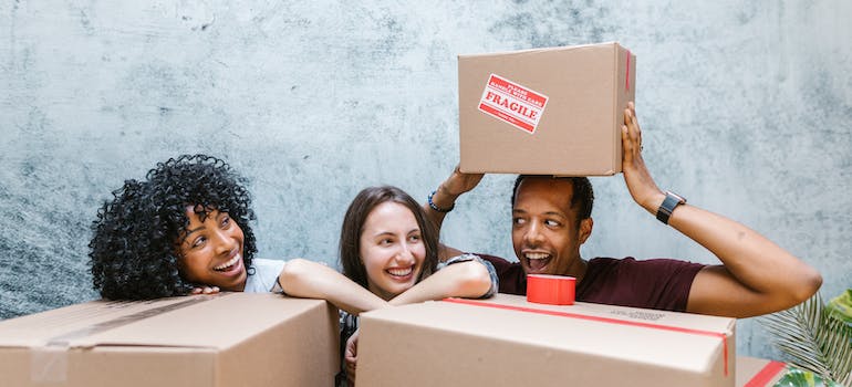 People holding moving boxes and thking how to reduce house moving costs in 2024