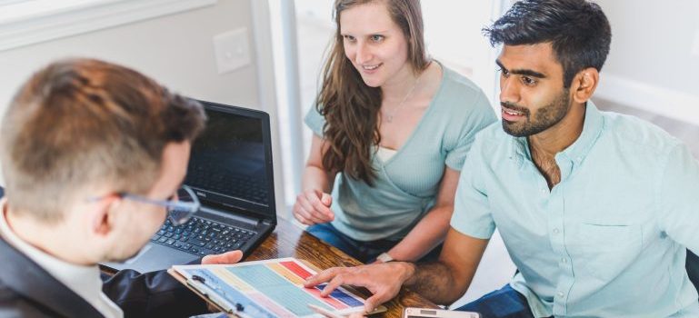 Couple talking to their real estate agent about the unexpected costs of moving to a new home in Ottawa