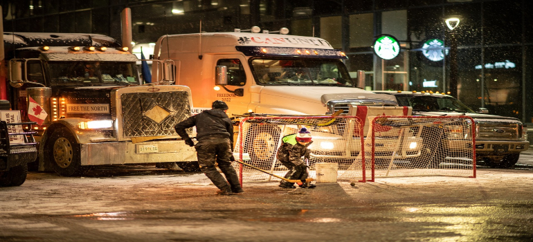 A man and a child playing hockey on the street