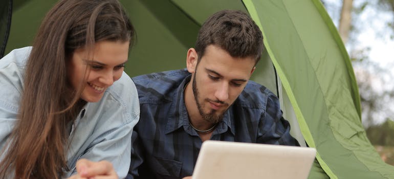 a man and a woman reading on a laptop about free and affordable things to see and do in Ottawa