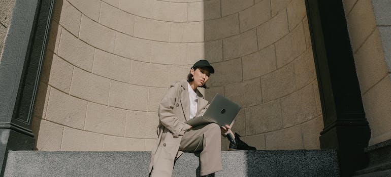 a woman sitting and reading on a laptop about free and affordable things to see and do in Ottawa