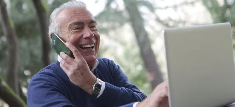 A senior talking on the phone and researching about Ottawa vs. Montreal
