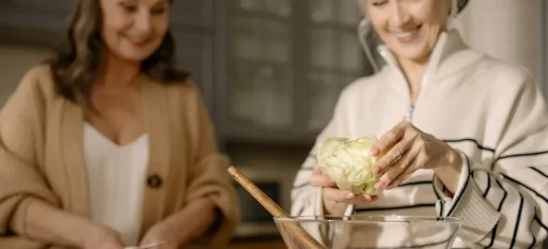 Two senior women preparing a salad