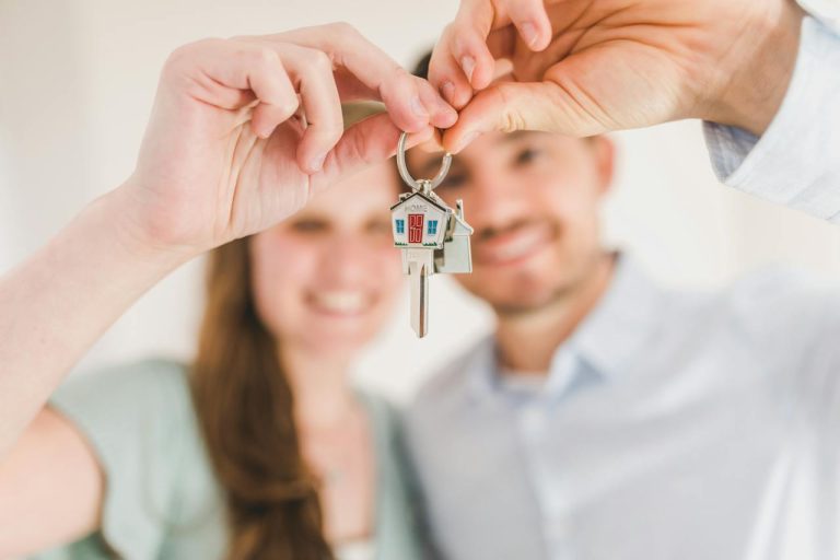 a man and a woman holding a house key after making a decision between renting vs. owning in Ottawa in 2024