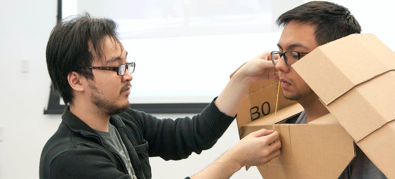 a man putting a box over other man's head