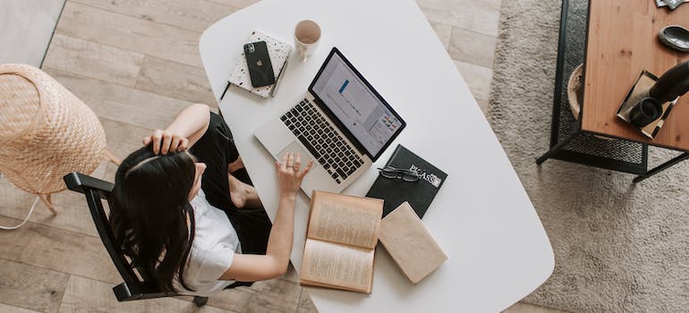 a young woman sitting and reading on a laptop
