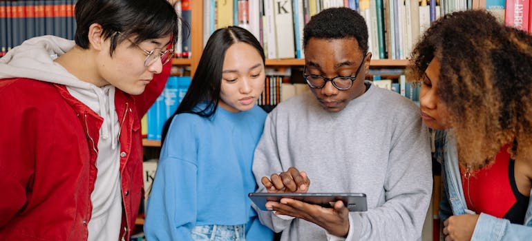 a group of people reading on a tablet about guide to student life in Ottawa