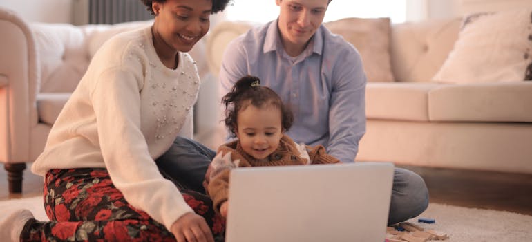 A family using a laptop to look into Canadian families moving with newborns.