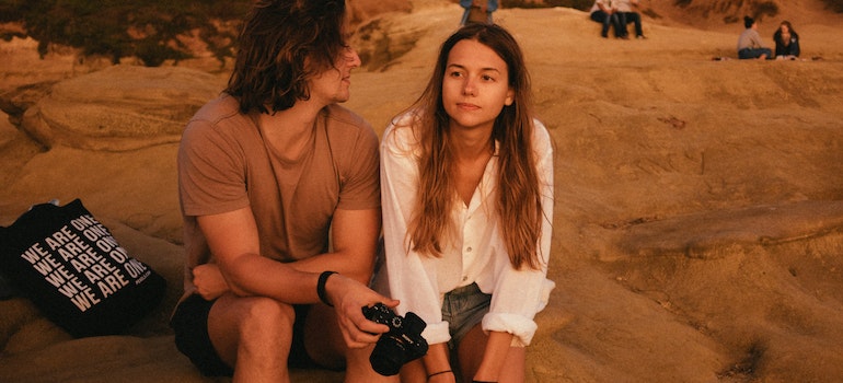 A couple discussing reasons to move from Chicago to Ottawa on a beach