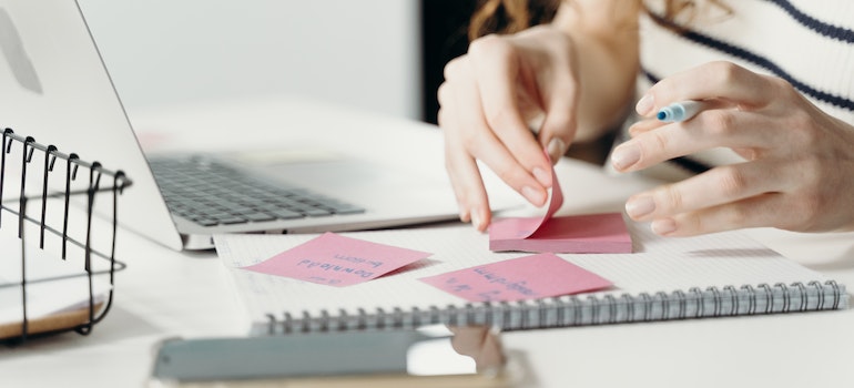 A woman writing pros and cons of living in Merrickville vs Smiths Falls