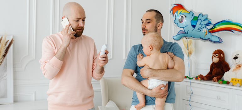 Two men talking while one is holding a baby