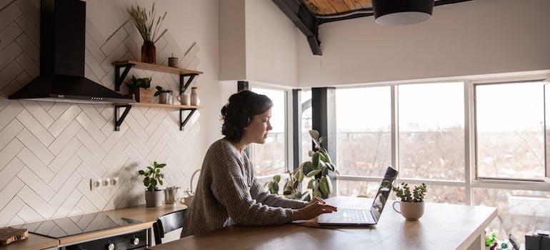 a woman reading on a laptop about how to improve your Ottawa home curb appeal