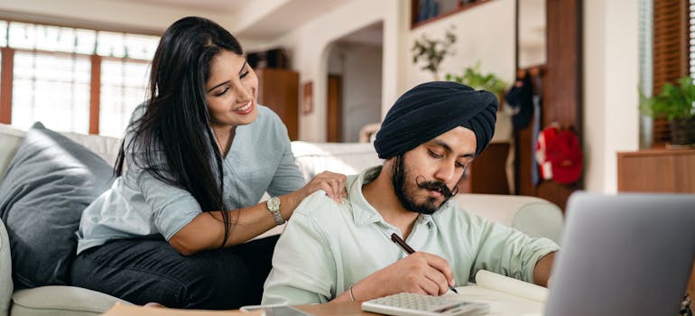 A couple budgeting while talking about Canadian families moving with newborns.