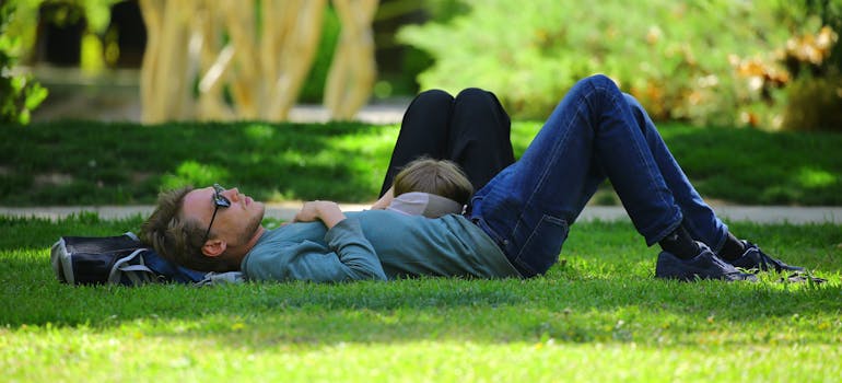 A man laying on grass and thinking about the pros and cons of moving to Barrhaven