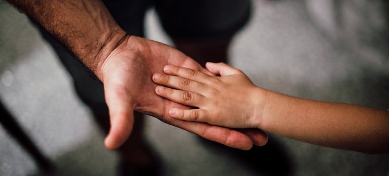 a father holding his kid's hand, which proves that embrun is ideal place to raise a family