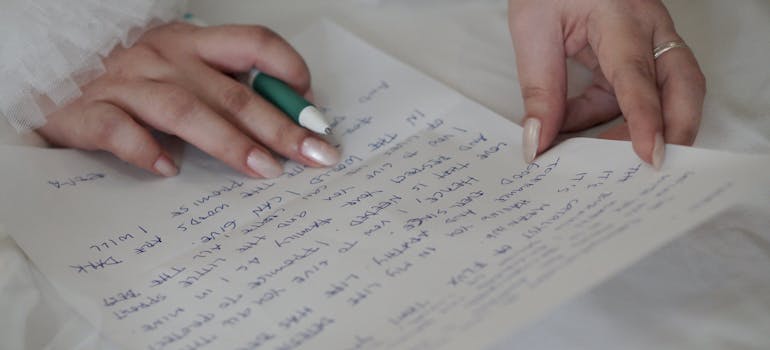 a woman holding a pen and writing a letter