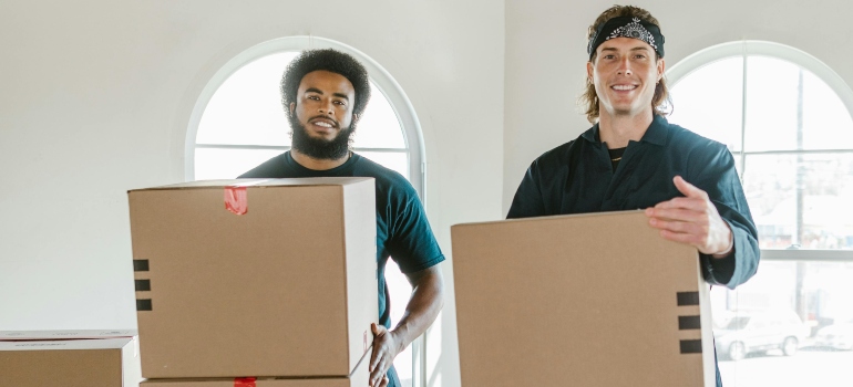 Two Men Standing Carrying Cardboard Boxes