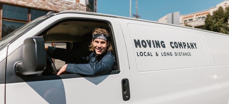 a man in blue sitting in a white van ready to help you with your moving to Arnprior with your pets
