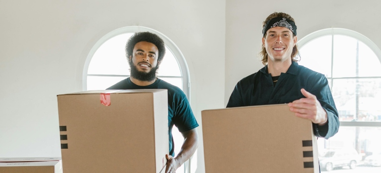 two men holding moving boxes