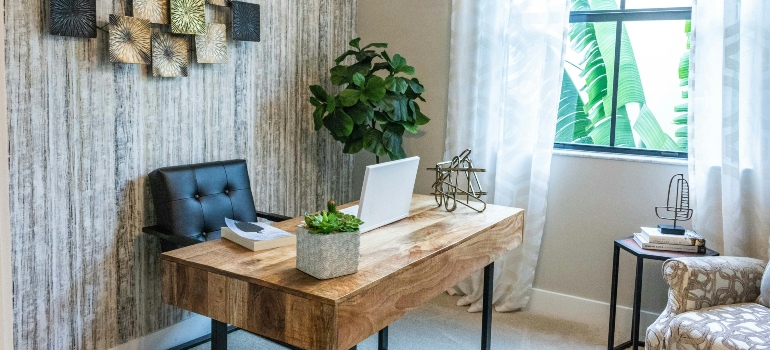 Home office with brown wooden table and lap top.