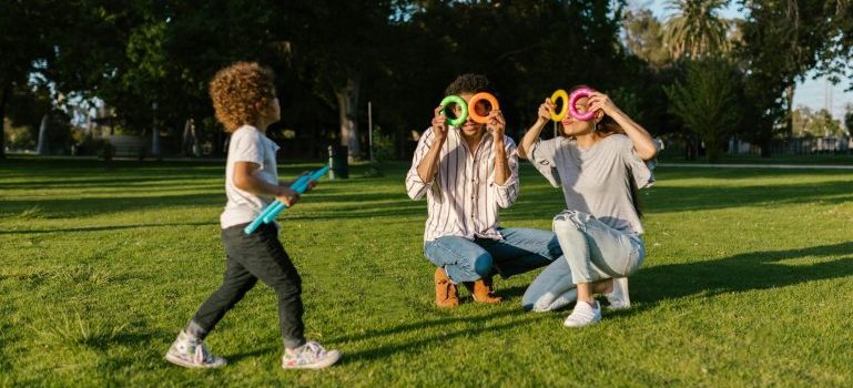 Two adults and a child playing in a park