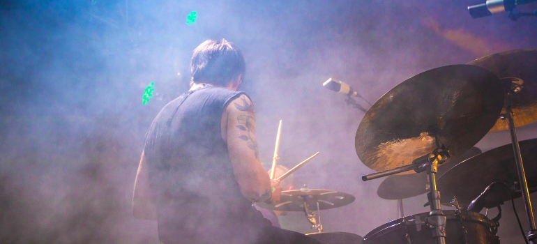 performing drummer surrounded with fogs