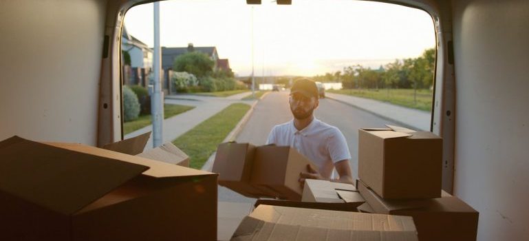 man putting boxes into a van