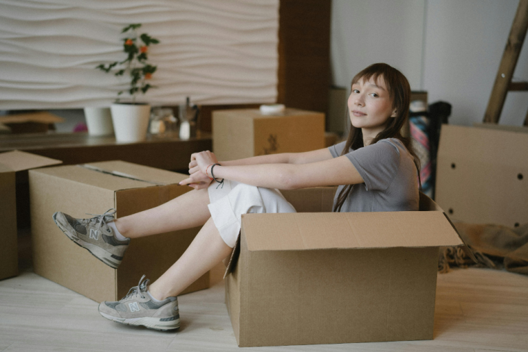 a girl sitting in a box, moving from Perth to Ottawa alone
