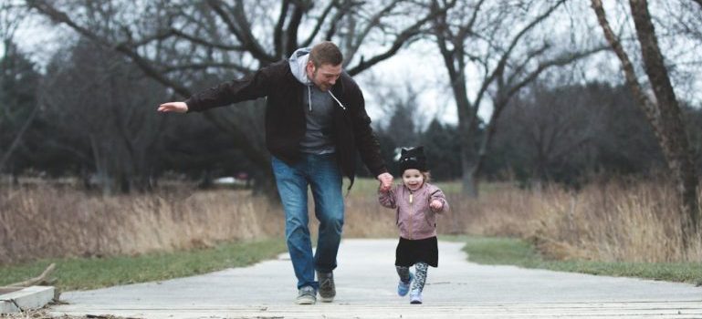 father and a child walking