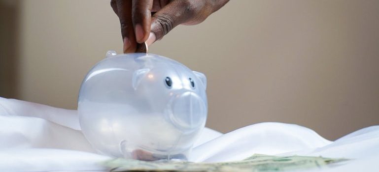 person putting a coin in a piggy bank